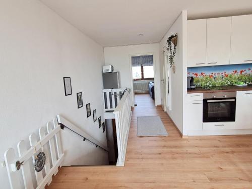 een keuken met witte kasten en een trap bij Ferienwohnung Kleine Auszeit in Sankt Englmar