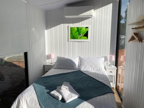ein Schlafzimmer mit einem Bett mit Handtüchern darauf in der Unterkunft The Whistling Frog in Neerim South