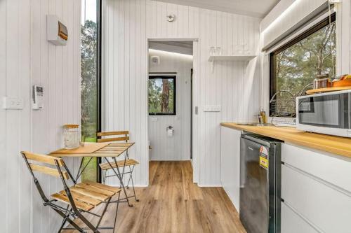 a kitchen with a counter and a table with chairs at Northern Grampians Getaway by Tiny Away in Dadswells Bridge