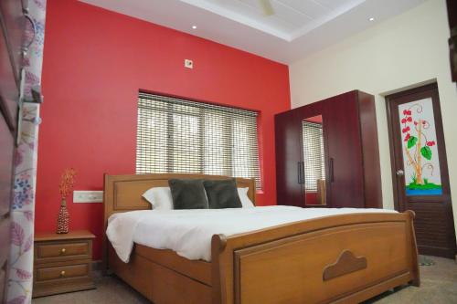 a bedroom with red walls and a large bed at Ashiaana Homestay in Trichūr