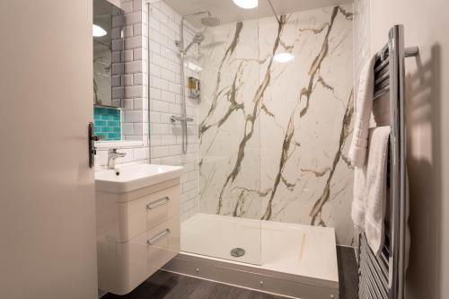 a white bathroom with a sink and a shower at Park View- 2 bed apartment close to East Surrey Hospital in Salfords