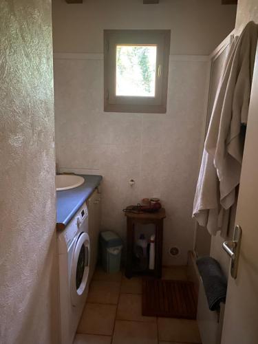 une petite salle de bain avec une machine à laver et une fenêtre dans l'établissement Chez Claire, à Brengues