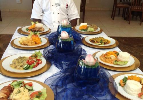 un tavolo sormontato da piatti di cibo di Marang Gardens Lodge a Mahikeng