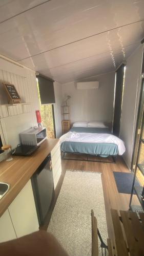 a room with a bed in a tiny house at Hill Creek 3 Tiny House in Perwillowen
