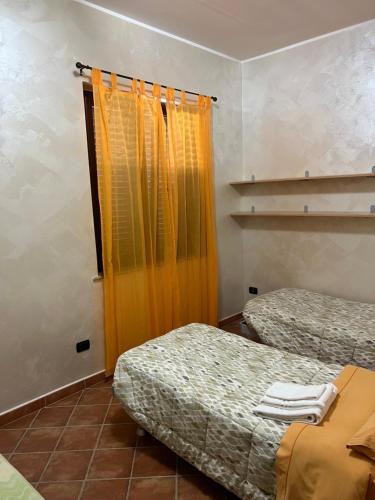 a room with two beds and an orange curtain at La Marinella in Palmi