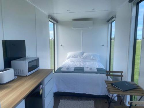 a bedroom with a bed and a desk with a tv at Lough View Cabin in Rosebrook