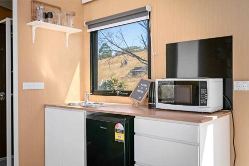eine Küche mit einer Theke mit einer Mikrowelle und einem Fenster in der Unterkunft Montara Views 4 in Ararat