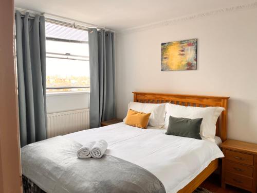 een slaapkamer met een bed met twee schoenen erop bij Hyde park,2 Bedrooms 2Bathrooms, Perfect for Families! in Londen