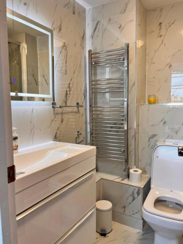 een witte badkamer met een bad en een toilet bij Hyde park,2 Bedrooms 2Bathrooms, Perfect for Families! in Londen