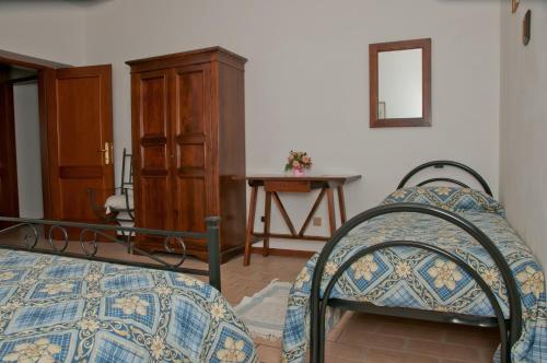 a bedroom with a bed and a dresser and a table at Agriturismo Casella Del Piano in Gubbio