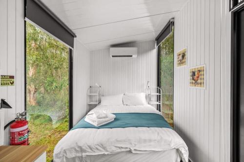 um quarto com uma cama e uma grande janela em Clarence Farm Stay em Maclean