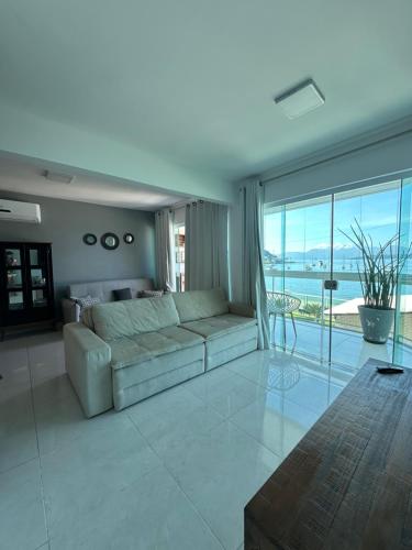 a living room with a couch and a view of the ocean at Praia Grande, Angra dos Reis in Angra dos Reis