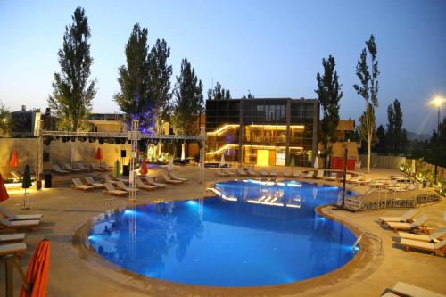 a large swimming pool with lounge chairs and a building at Layali Al Shams Hotel in ‘Anjar