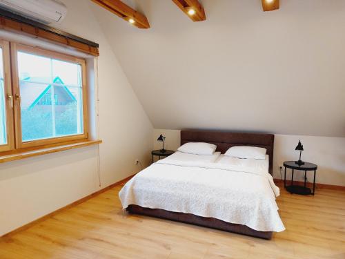 a bedroom with a bed and a large window at Apartamentai Emilija in Nida