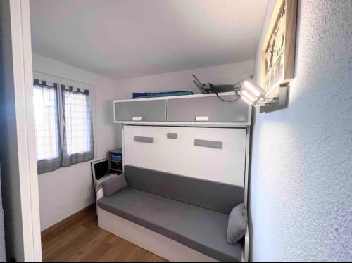 Cette chambre comprend un réfrigérateur avec une étagère et une fenêtre. dans l'établissement Appartement T2 vue mer port-leucate accès direct plage avec piscine et ascenseur port leucate, à Leucate