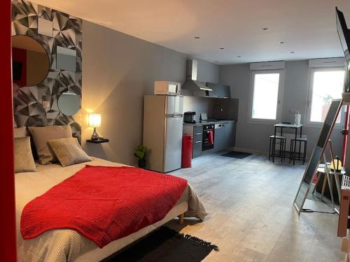 a bedroom with a bed with a red blanket on it at Le studio urbain qu’il vous faut ! in Saint-Dizier