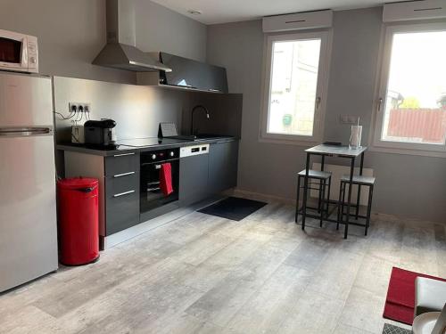 a kitchen with a stove and a refrigerator and a table at Le studio urbain qu’il vous faut ! in Saint-Dizier