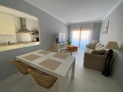 a living room with a white table and a couch at Albatros Apartamentos Playa Granada in Motril