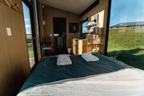 ein Schlafzimmer mit einem Bett mit zwei Handtüchern darauf in der Unterkunft Mighty Tiny House 2 in Ruawaro