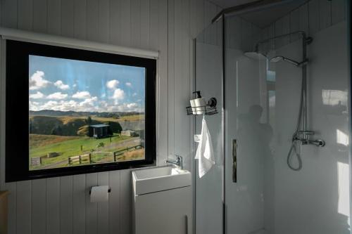 a bathroom with a window with a view of a field at Mighty Tiny House 1 in Ruawaro