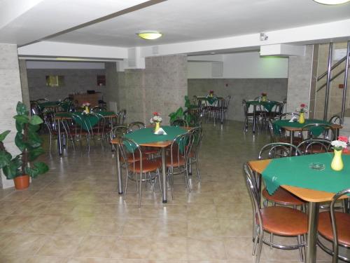 un comedor con mesas verdes y sillas en Hotel Zimbru en Cluj-Napoca