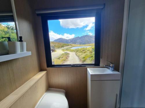 a bathroom with a window and a toilet and a sink at Lake Stella 1 - Falcons Nest in Mt Lyford