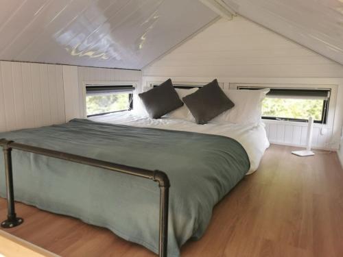 ein Schlafzimmer mit einem großen Bett in einem kleinen Zimmer in der Unterkunft Sweet Hart 1 in Tamahere