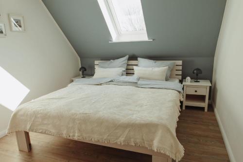 a bedroom with a bed with white sheets and a window at Gästehaus Bröcker Wohnung 7 in Büsum
