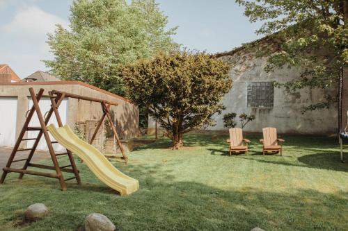 a playground with a slide and two chairs in a yard at Gästehaus Bröcker Wohnung 7 in Büsum