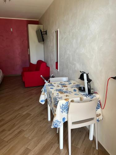 a room with a table and chairs and a red couch at La Marinella in Palmi