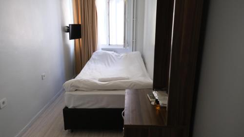 a small room with a bed and a window at Simon Hotel in Istanbul