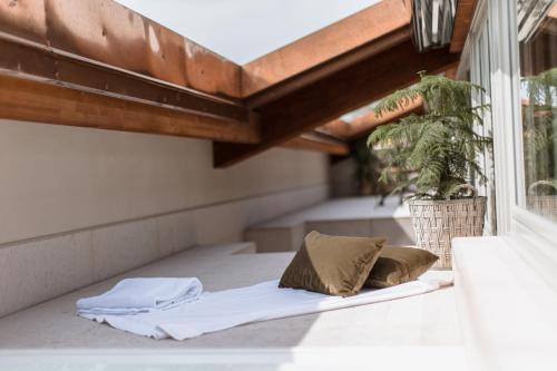 a bed with two pillows on a balcony with a plant at Pavillon Suite in Peschiera del Garda