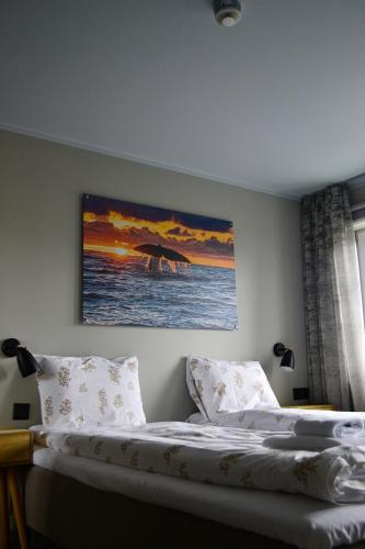 a bedroom with a bed with a painting on the wall at Andenes Suitehotel in Andenes