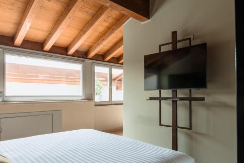 a bedroom with a bed and a tv on the wall at Pavillon Suite in Peschiera del Garda