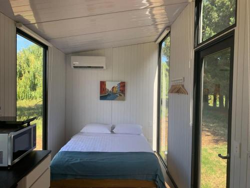 a bedroom in a tiny house with a bed at Arariri River Rest in Springston