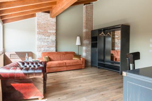 a living room with a leather couch and a fireplace at Pavillon Suite in Peschiera del Garda