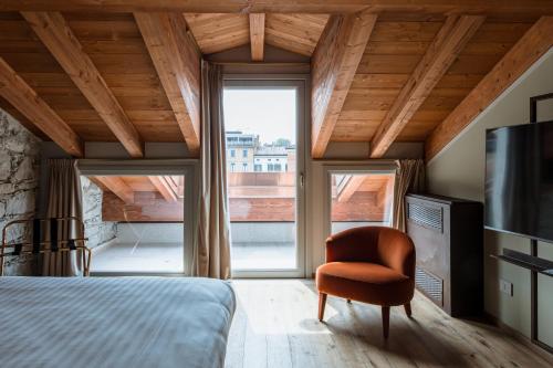 a bedroom with a bed and a chair and a large window at Pavillon Suite in Peschiera del Garda