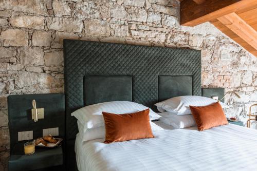 two beds in a bedroom with a stone wall at Pavillon Suite in Peschiera del Garda