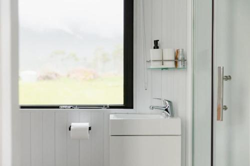 La salle de bains est pourvue d'un lavabo et d'une fenêtre. dans l'établissement The Coast 1, 