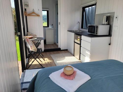 uma pequena cozinha com uma cama numa pequena casa em Deloraine Tiny Retreat em Whangarei
