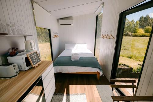 a bedroom with a bed in a tiny house at Harrington's on the Terrace - Murchison in Te Anau