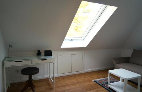 ein Wohnzimmer mit einem Dachfenster, einem Schreibtisch und einem Sofa in der Unterkunft Villa Buchholz in Arnstadt
