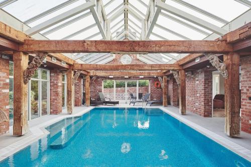 una piscina cubierta con techo de cristal y paredes de ladrillo en Victoria Lodge, 