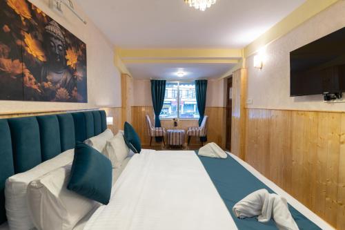 ダージリンにあるAvianna Seven Seas Darjeelingのベッド1台、薄型テレビが備わるホテルルームです。