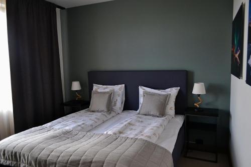 a bedroom with a large bed with white sheets and pillows at Andenes Suitehotel in Andenes