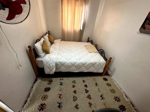 Dormitorio pequeño con cama con alfombra en Mabidi Surf Camp Morocco en Taghazout