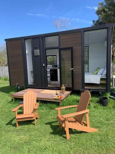 a tiny house with two chairs and a table at The Coast 2 