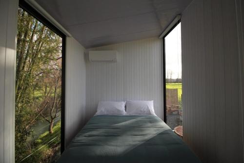 a bed in a room with a large window at Breathe Inn in Kaitaia