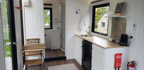 uma pequena cozinha com um lavatório e um balcão em Colca Creek Tiny House em Lawrence
