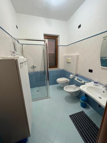 a bathroom with two sinks and a shower and a toilet at La Marinella in Palmi
